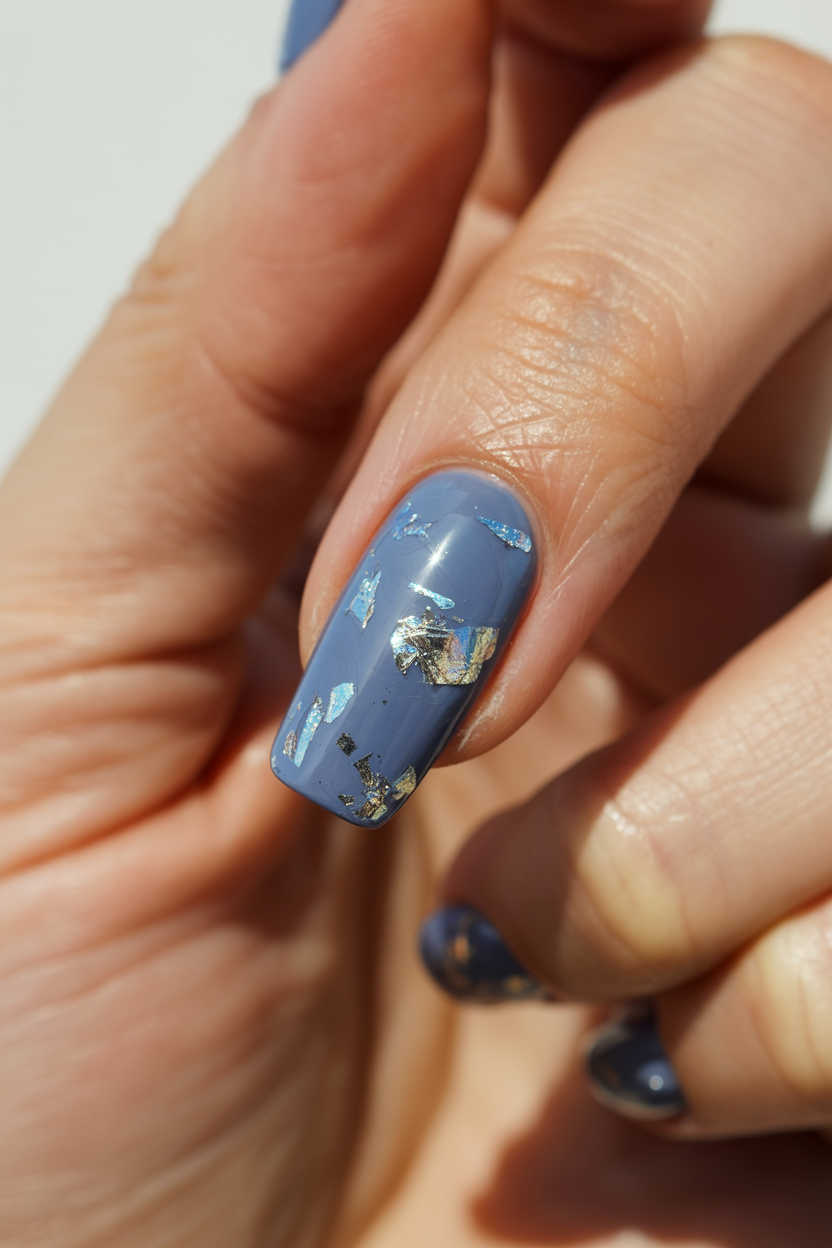 Embedded Foil Flakes nail design — Sheer blue base with irregular silver or iridescent flakes suspended inside.