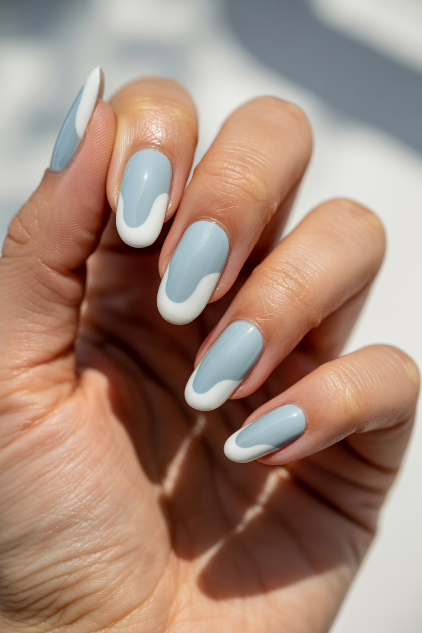 White Foam Tips nail design — An irregular, wavy white tip on a pale blue base, like surf hitting the shore.