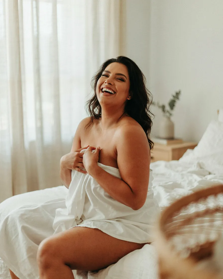 Laughing Candid in the Sheets plus size boudoir photoshoot idea
