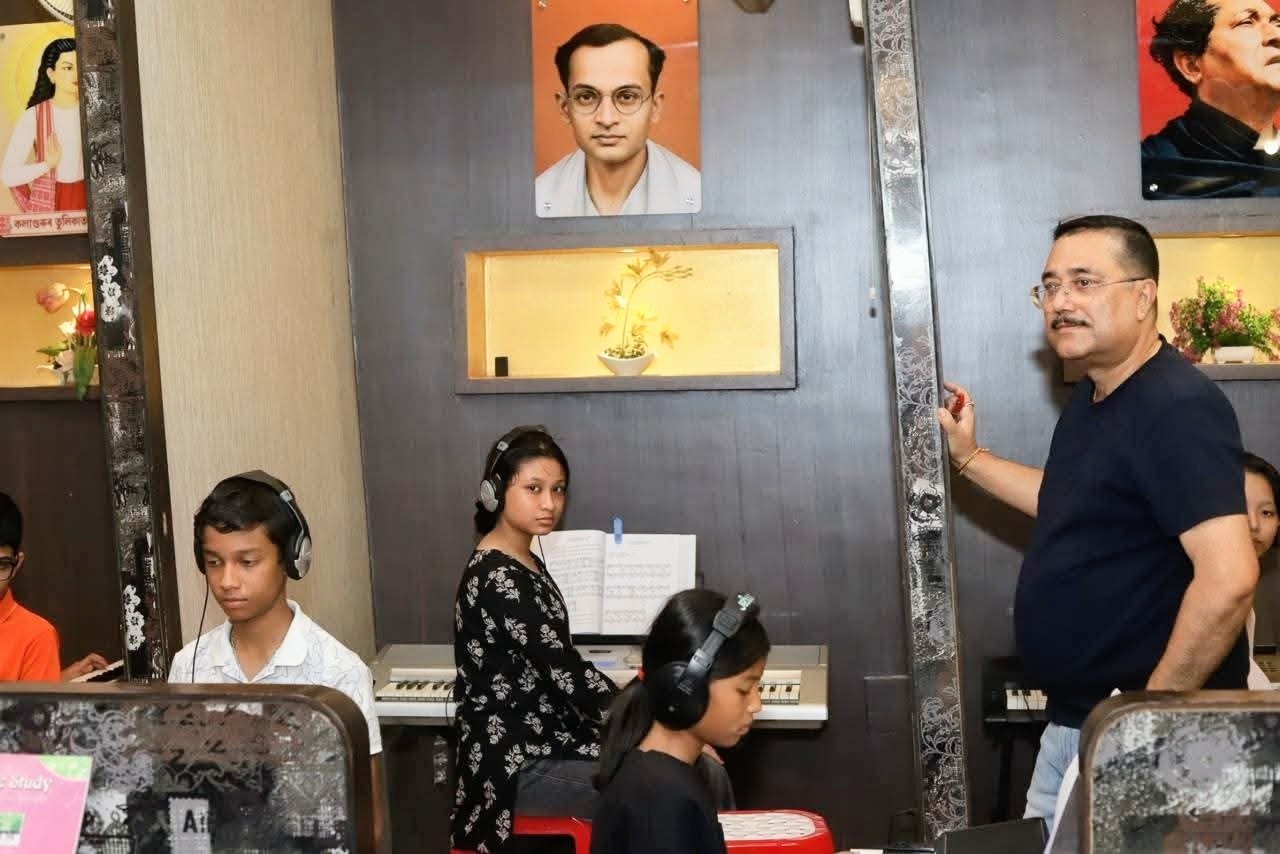 Students practising on keyboards with headphones at Piano Kids